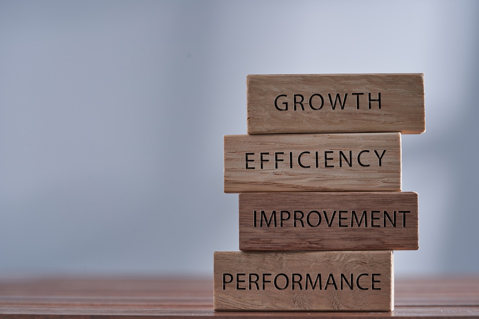 Business management related words growth, efficiency,improvement and performance on wooden blocks